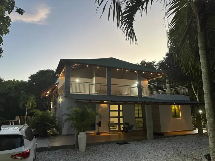 La casa con las luces encendidas al caer la tarde