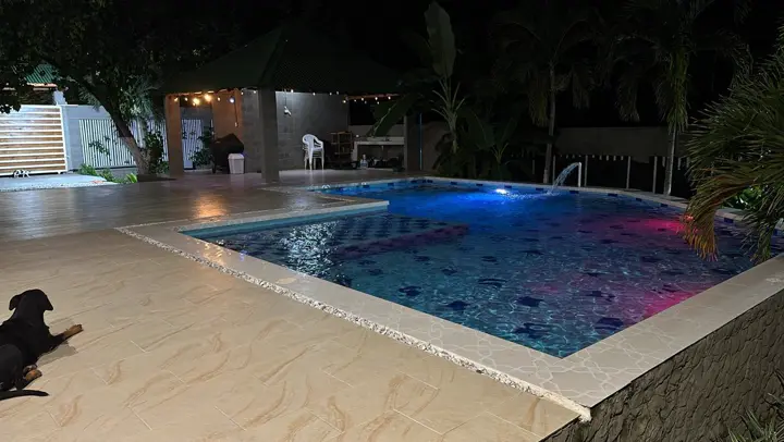 Piscina iluminada de noche junto al kiosko