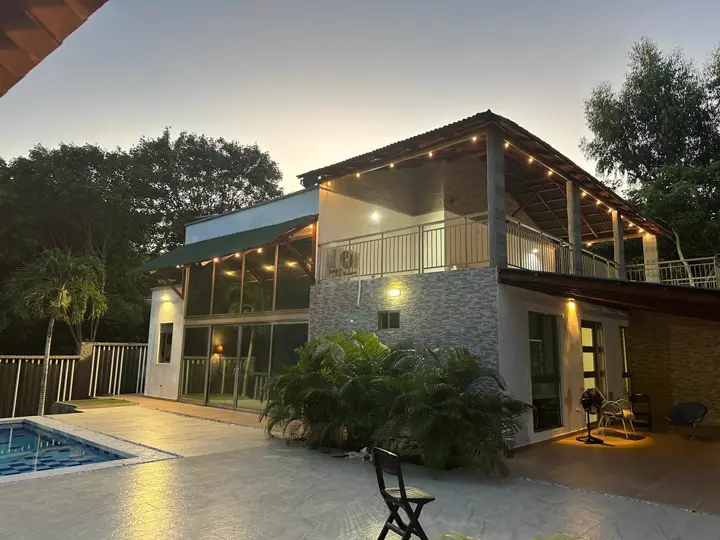 La casa al atardecer, con las terrazas iluminadas y la piscina